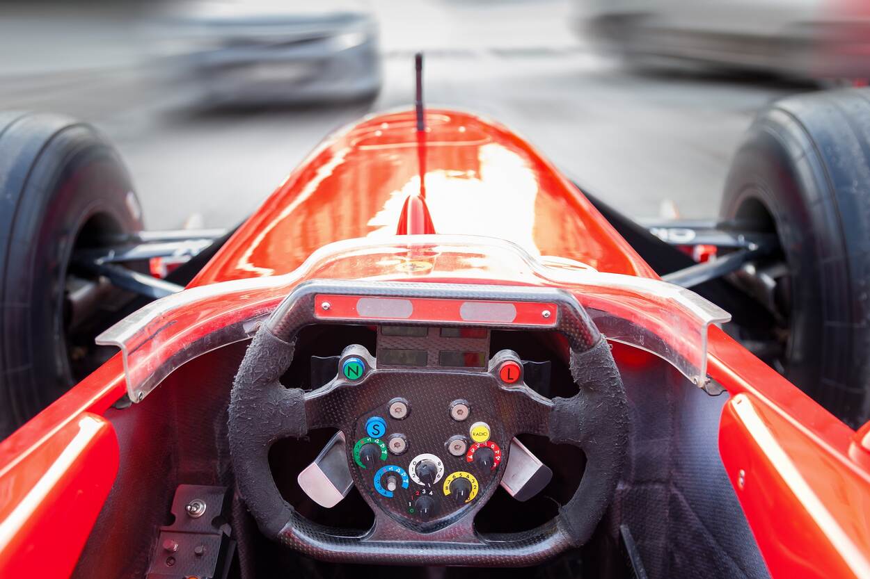 Blik op het dashboard en de weg vanuit een rode raceauto