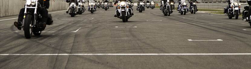 Een groep motorrijders rijden naast elkaar over het asfalt