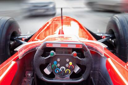 Blik op het dashboard en de weg vanuit een rode raceauto